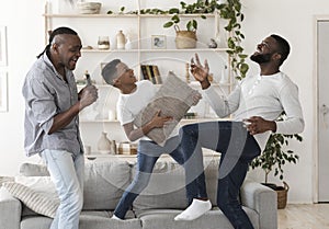 Black boy, his dad and grandfather dancing and singing in living room