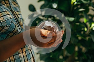 Black boy holding crystal globe on hands