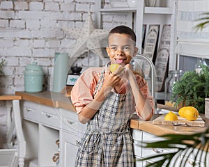 Black boy kid cooking fresh lemon on kitchen at home. African child preparing on table.