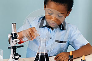 Black boy mixing chemicals in lab