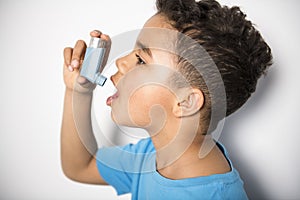 A black Boy using an asthma inhaler