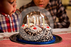 Black boys blow candles out. photo