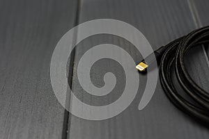 Black braided fabric cable with lightning terminal for connection of electronic devices