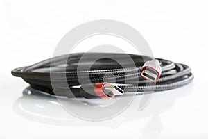 Black braided wire with two red-black usb type-c connectors on a light background. Modern way to connect, transfer data and charge