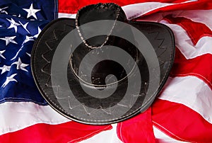 Black brimmed cowboy hats on the background of the flag of the united states of america