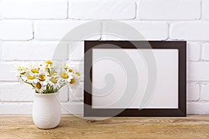 Black brown landscape frame mockup with chamomile bouquet in ru