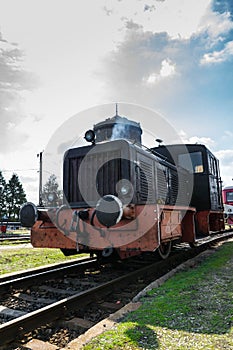 Black & brown old diesel locomotive stationary on railway