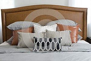 Pillows setting on bed with brown leather headboard photo