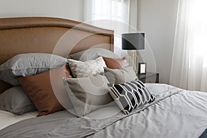 Pillows setting on bed with brown leather headboard