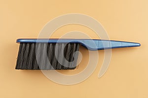 Black brush with blue handle on beige