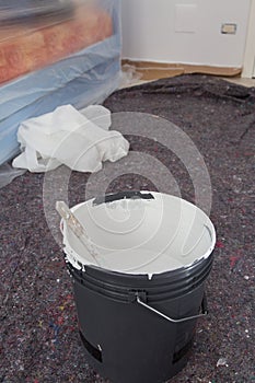 Black Bucket and PaintBrush and Room with Furniture with Protective Sheeting