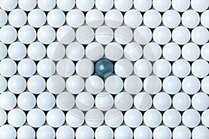 Black bulb among many white ones. Background of airsoft balls