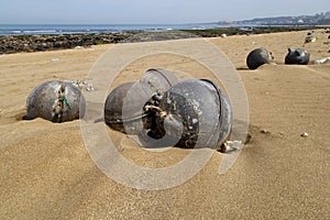 Black buoys on a beach