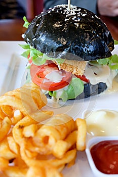 Black burger, cheese, tomatoes, mayonnaise, french fries