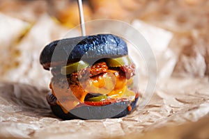 Black burger delivery.Delicious fast food delivered in crafted brown paper.Big tasty cheeseburger with burned cheddar cheese,