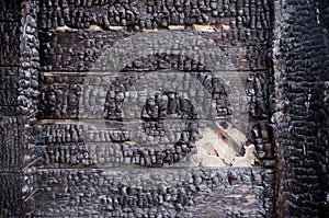 Black burnt wall of house of wooden planks with embossed texture. damage to the building from fire without the possibility of