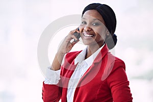 Black business woman smiling while standing and talking on phone