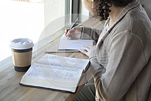 Black woman studies her bible and takes notes photo