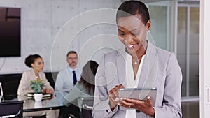 Black business woman using digital tablet in meeting room