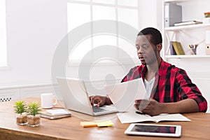 Black businessman in casual office, work with laptop and documents