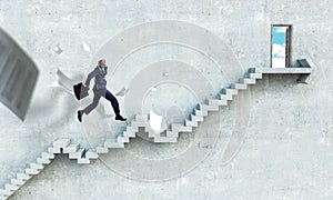 Black businessman climbing stone stairs illustrating career development and success concept. Mixed media