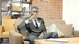 Black Businessman Drinking Water, Sitting in Office