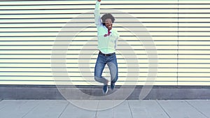 Black Businessman jumping outdoors. Man with afro hair.