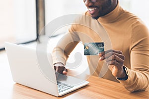 Black businessman making purchases using laptop computer