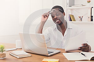 Black businessman in office, work with laptop and documents