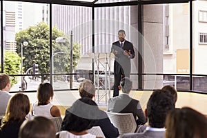 Black businessman presenting seminar gesturing to audience