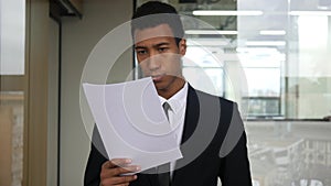 Black Businessman Reading Documents in Office