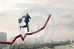 Black businessman running on red increasing arrow