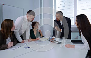 Black businessman showing graphics to team at meeting