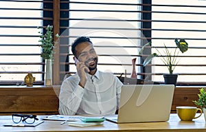 Black businessman talking on cell phone at office.