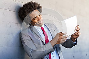 Black Businessman using a digital tablet in urban background photo