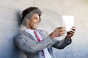 Black Businessman using a digital tablet in urban background photo