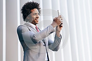 Black Businessman using a smartphone near an office building photo