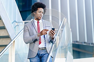 Black Businessman using a smartphone near an office building photo