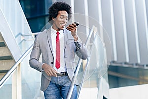 Black Businessman using a smartphone near an office building photo