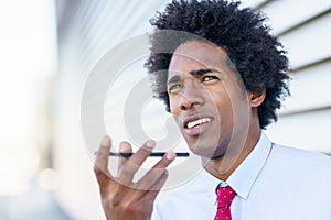 Black Businessman using a smartphone near an office building photo