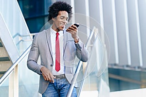 Black Businessman using a smartphone near an office building photo