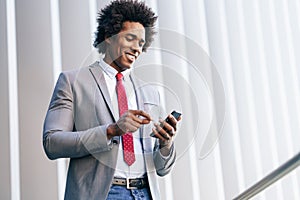 Black Businessman using a smartphone near an office building photo