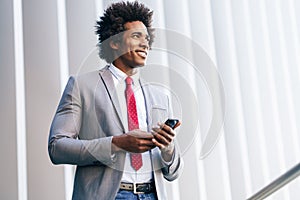 Black Businessman using a smartphone near an office building photo