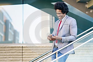 Black Businessman using a smartphone near an office building photo