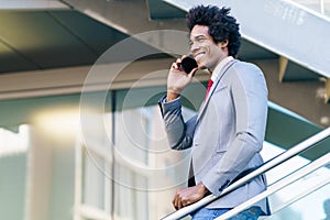 Black Businessman using a smartphone near an office building photo