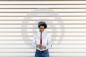 Black Businessman using a smartphone with a white blinds background photo