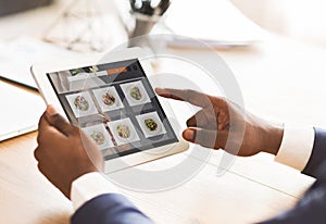 Black Businessman Using Tablet Ordering Food Online Sitting In Office