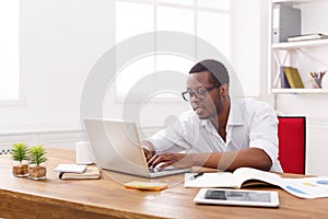 Black businessman in white office, work with laptop