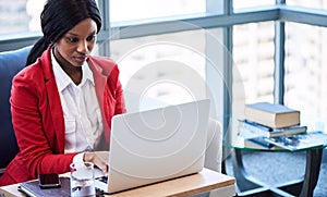 Black businesswoman busy working while looking at her computer screen