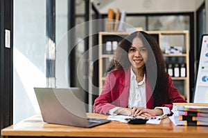 Black Businesswoman Sitting at Her Desk Working on a Laptop Computer. Smiling Successful African American Woman working